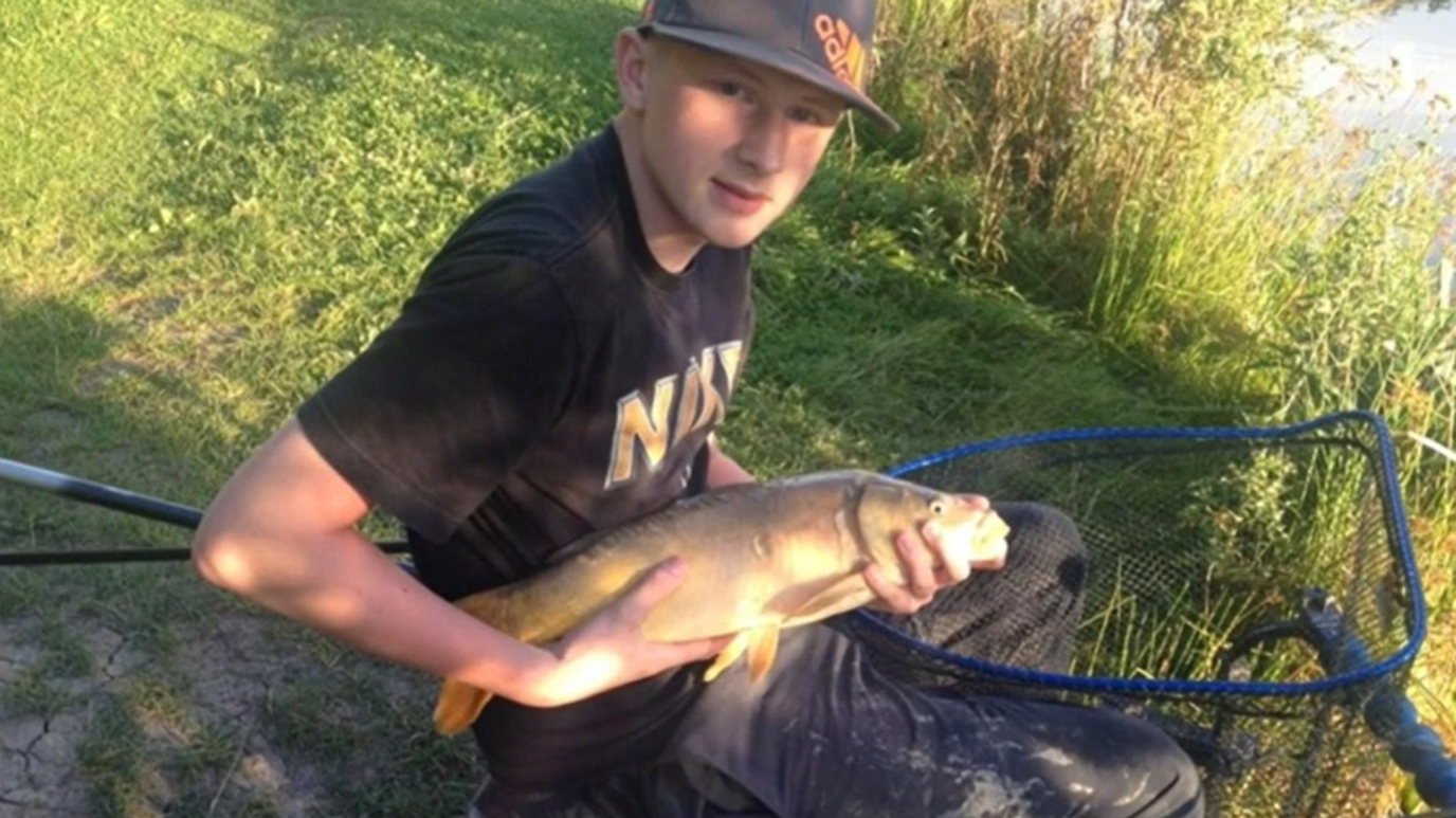 Kyle Asquith holding a fish near a net