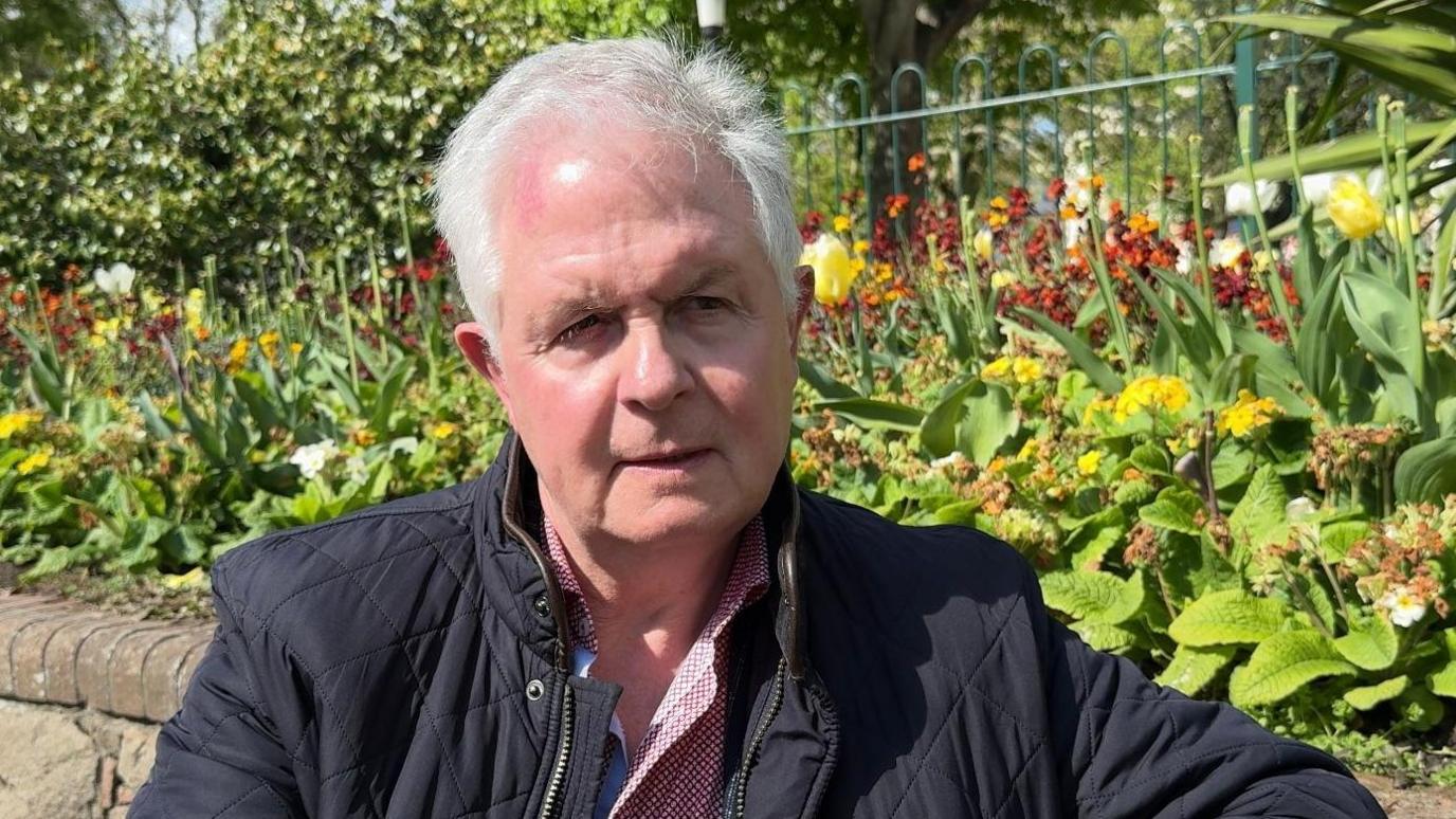Grey haired man in navy jacket