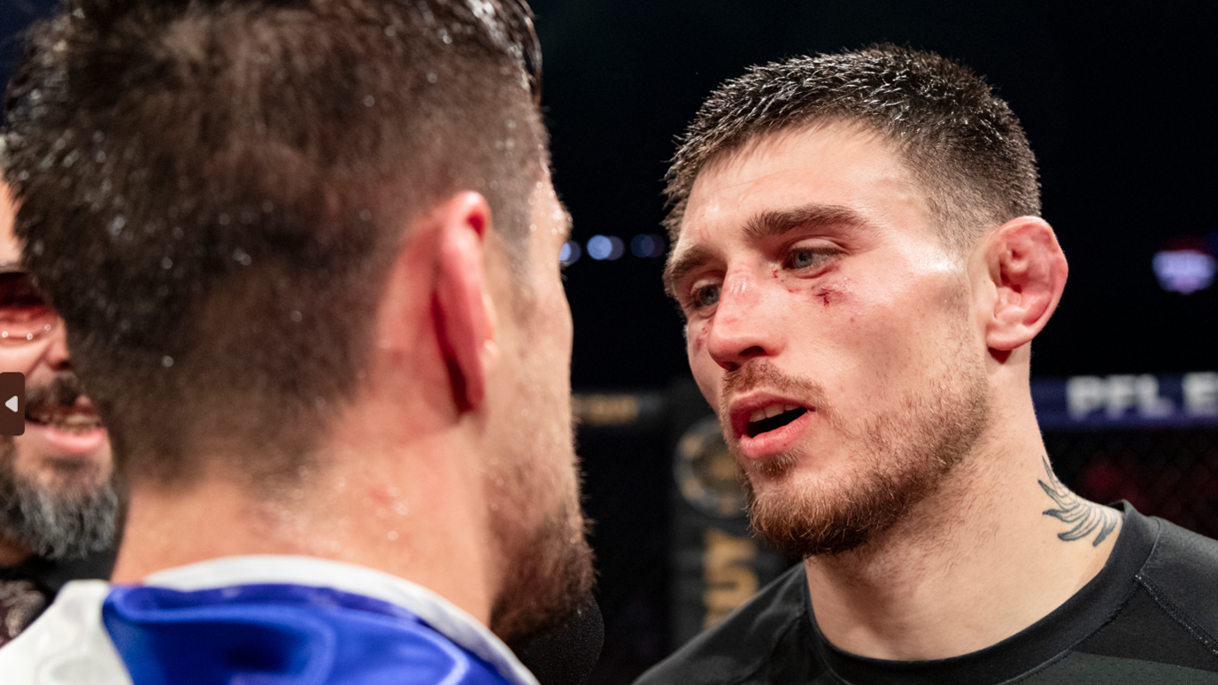 Close-up of bruised Connor Hughes in a face-off in the cage after a fight