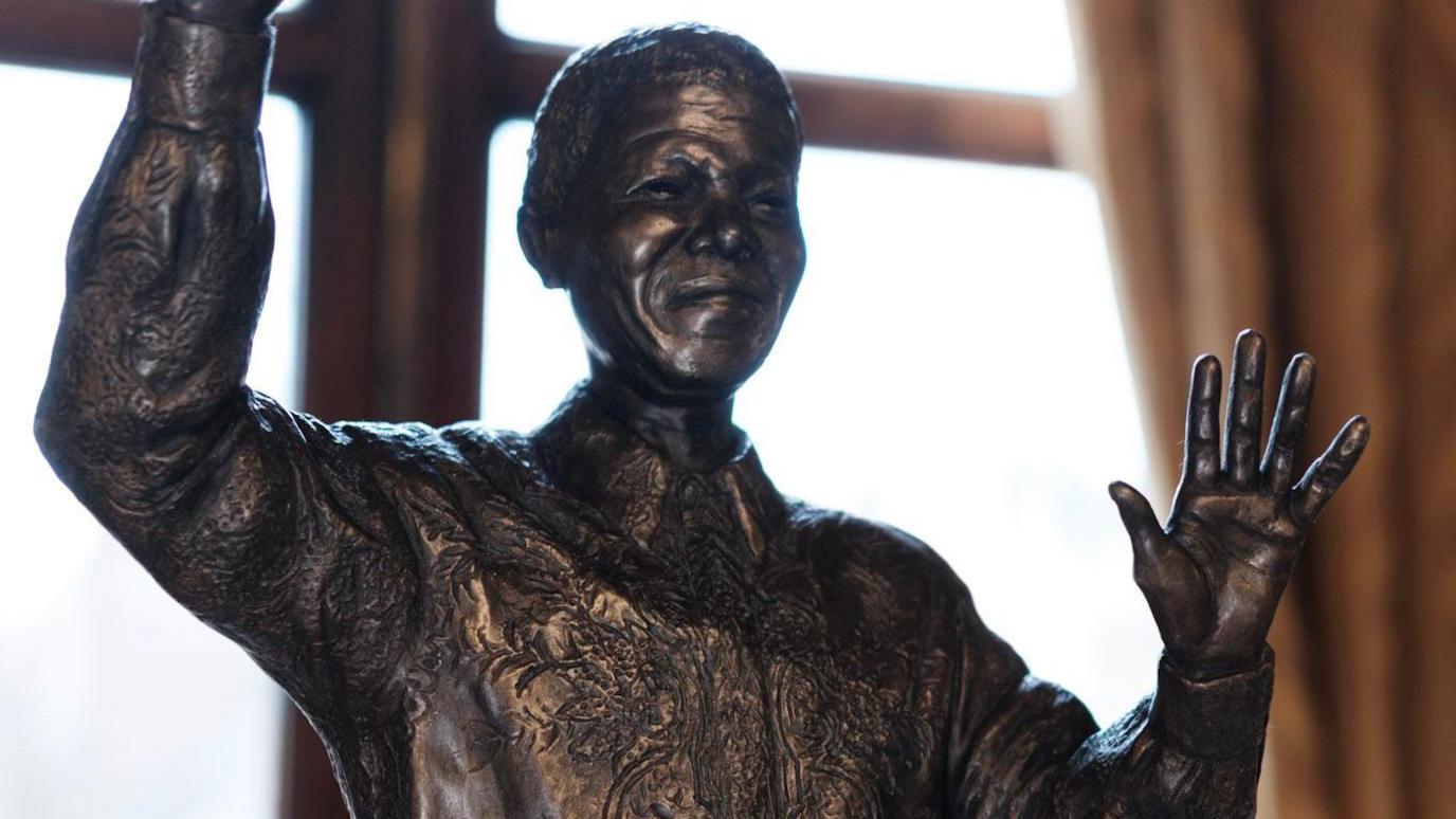 A proposed statue of Nelson Mandela. It has Mandela standing with one arm raised in the air and the other hand waving.