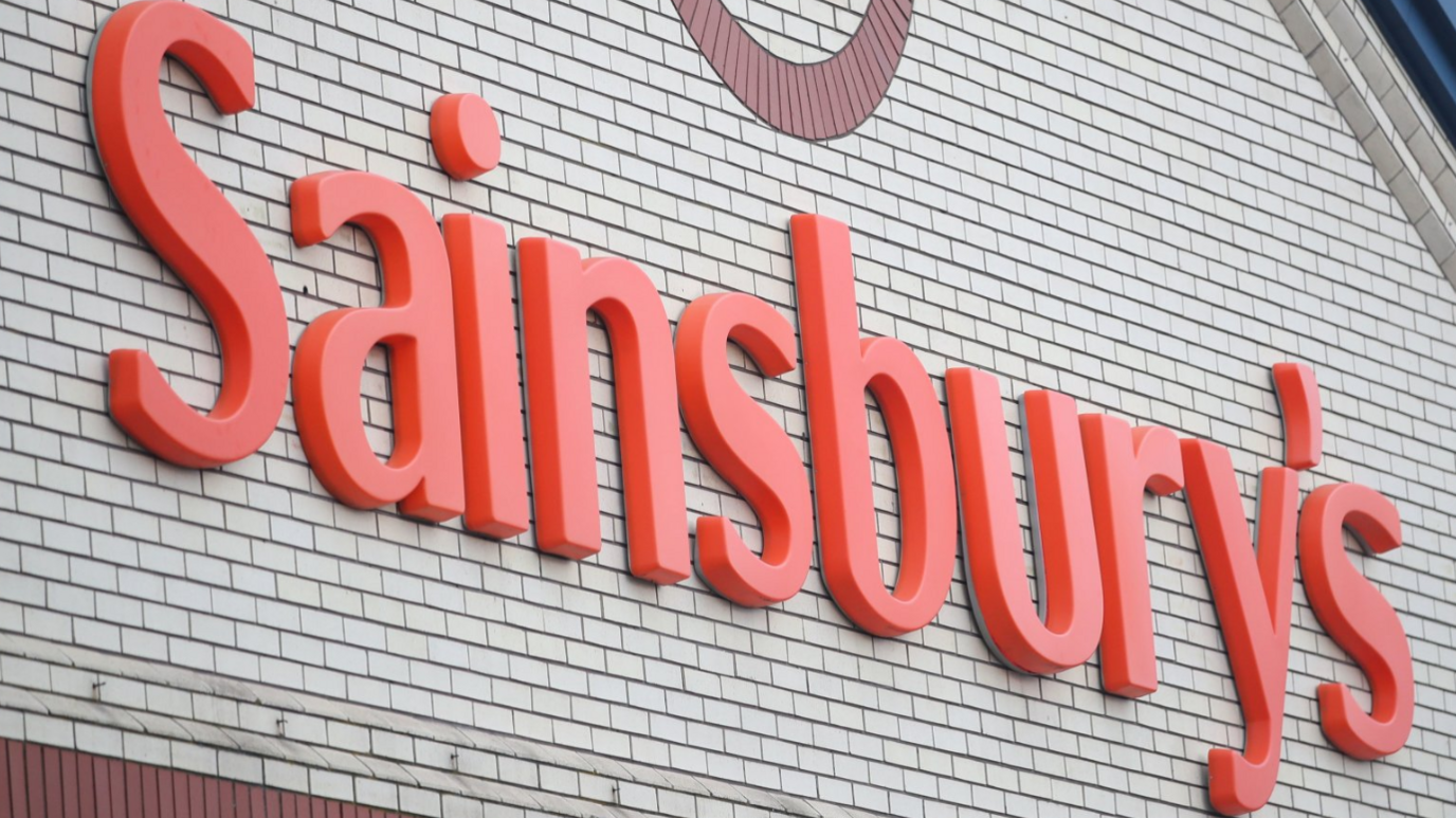 A close-up of the Sainsbury's sign, on the wall of a store