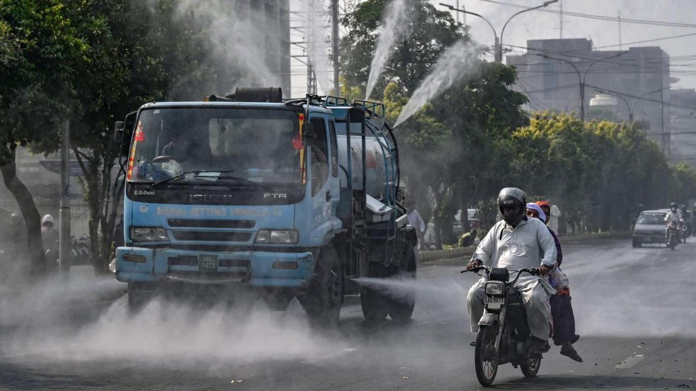 Water is sprayed from a truck in Lahore 