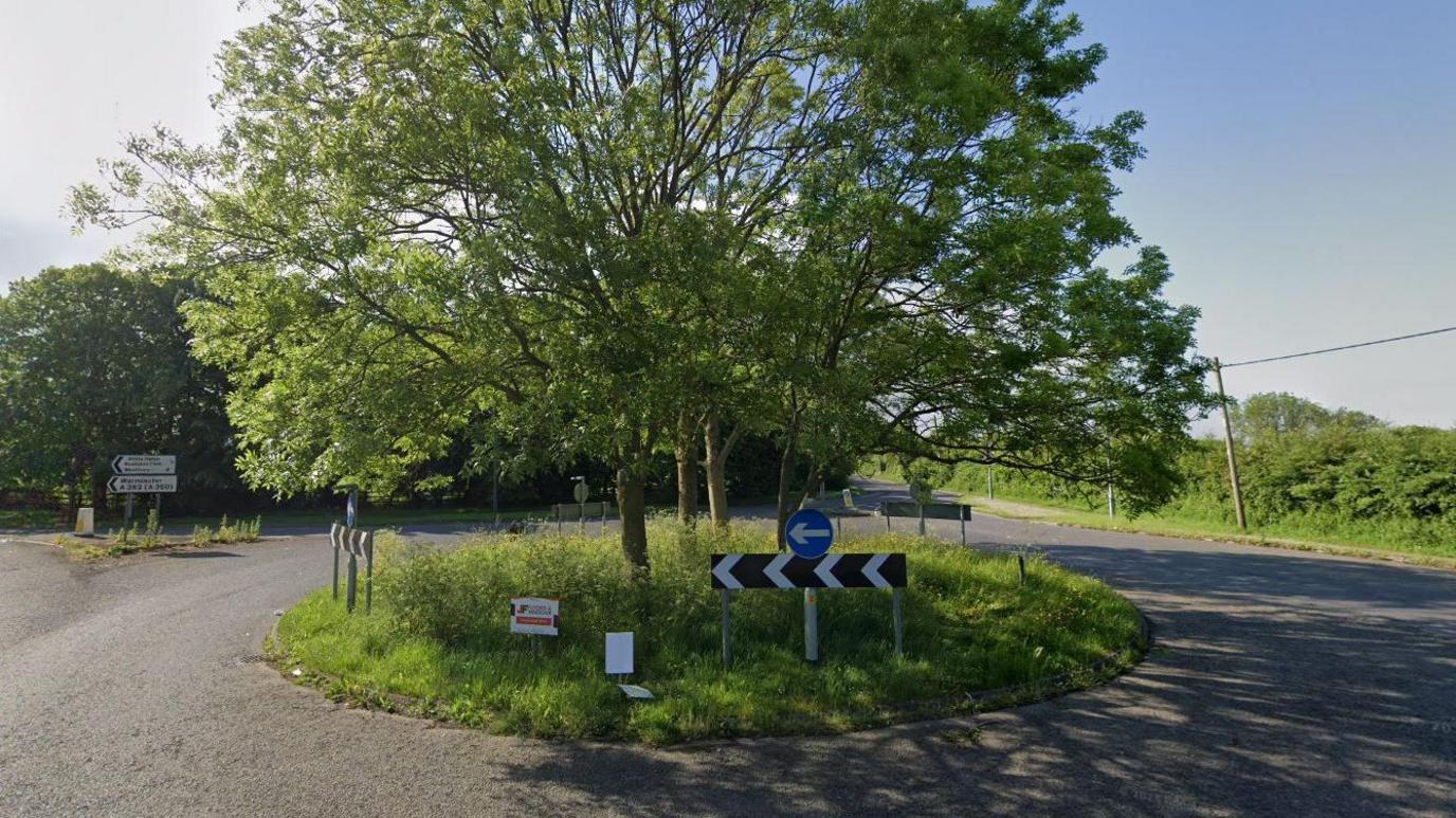 A roundabout with three trees growing in its centre