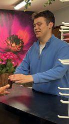 Jamie in a blue fleece handing over a plant