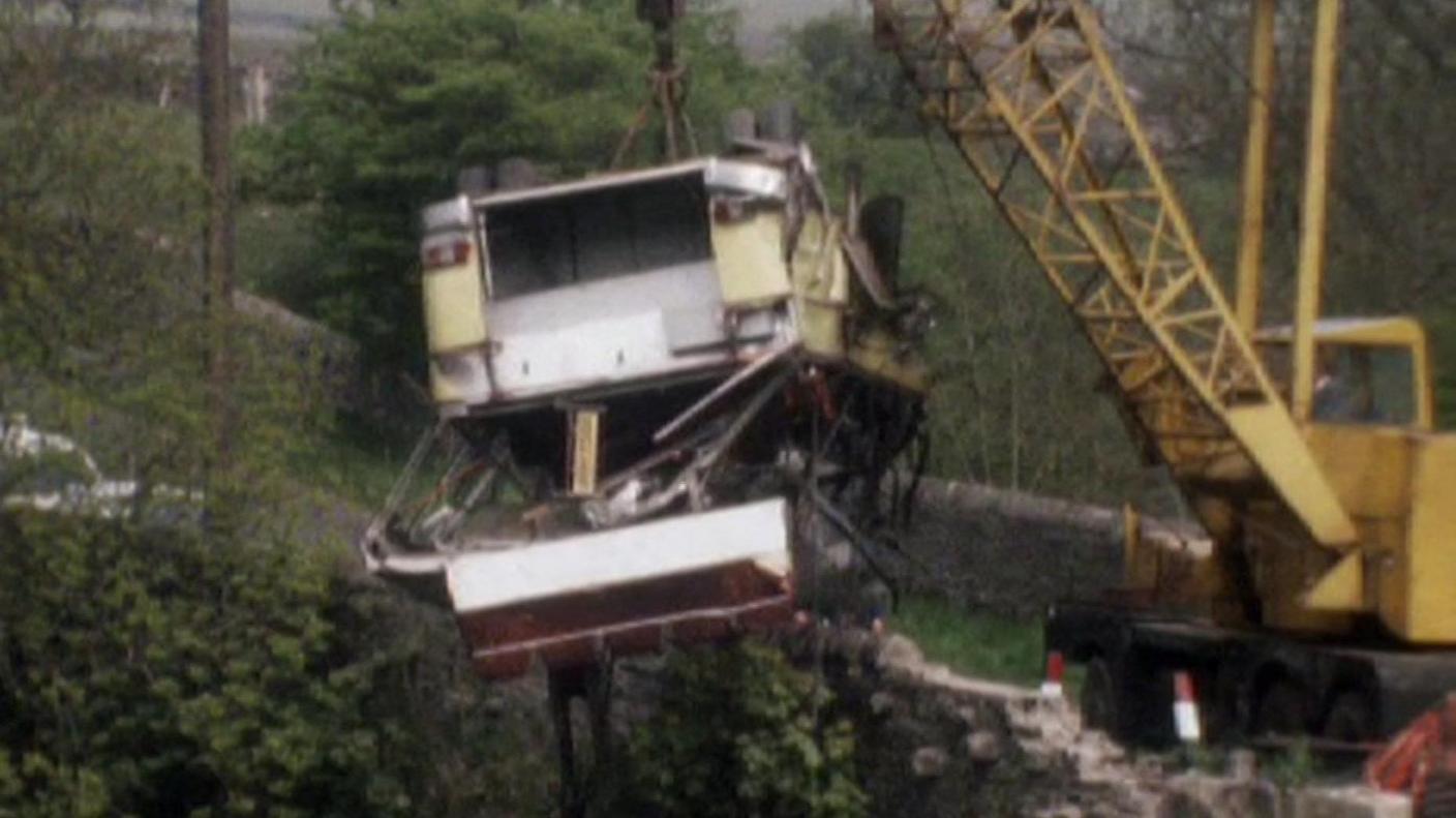 Archive pictures show a yellow crane lifting the wreckage of the coach