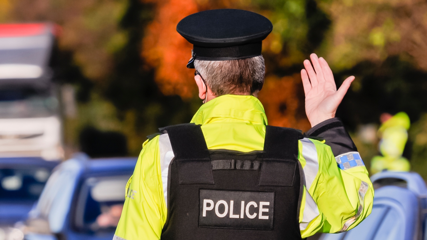 Back of police officer as he waves traffic forward