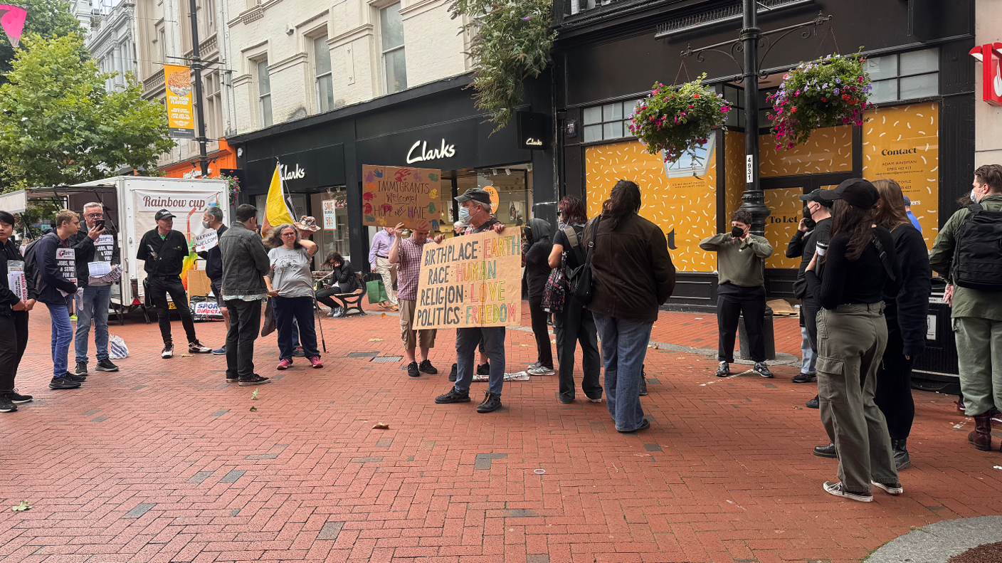 A protest - with about 20 people, including a man in a blue facemask holding a sign - in Broad Street in Reading 