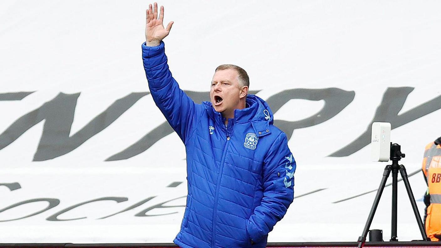 Coventry City boss Mark Robins raises his arm to appeal for a decision in the 3-2 comeback win over Luton Town