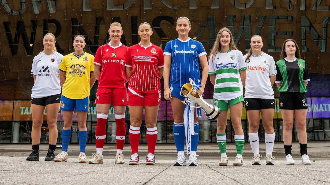 Players from all eight Adran Premier teams pose with trophy outside the Welsh Millennium Centre