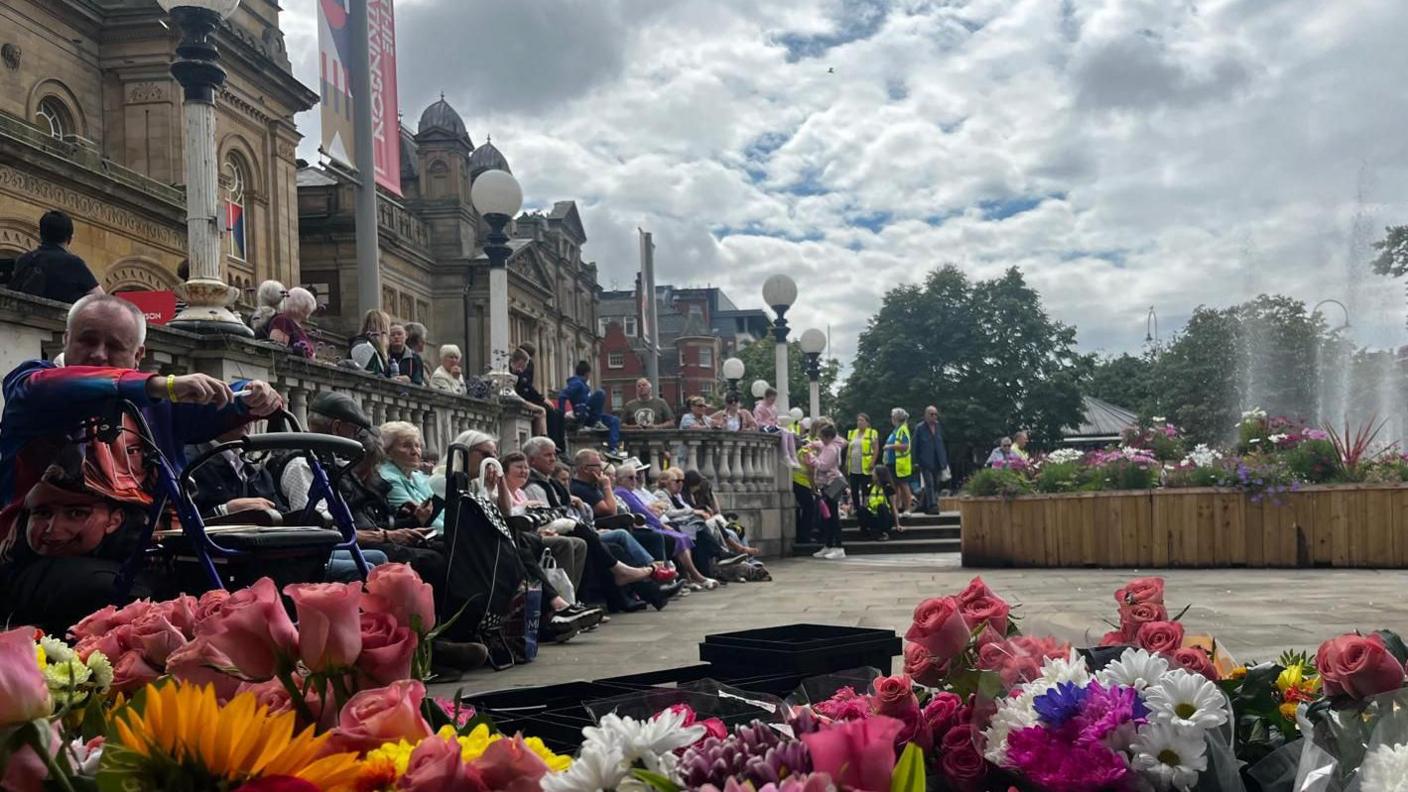 People sit in silence outside Southport Town Hall