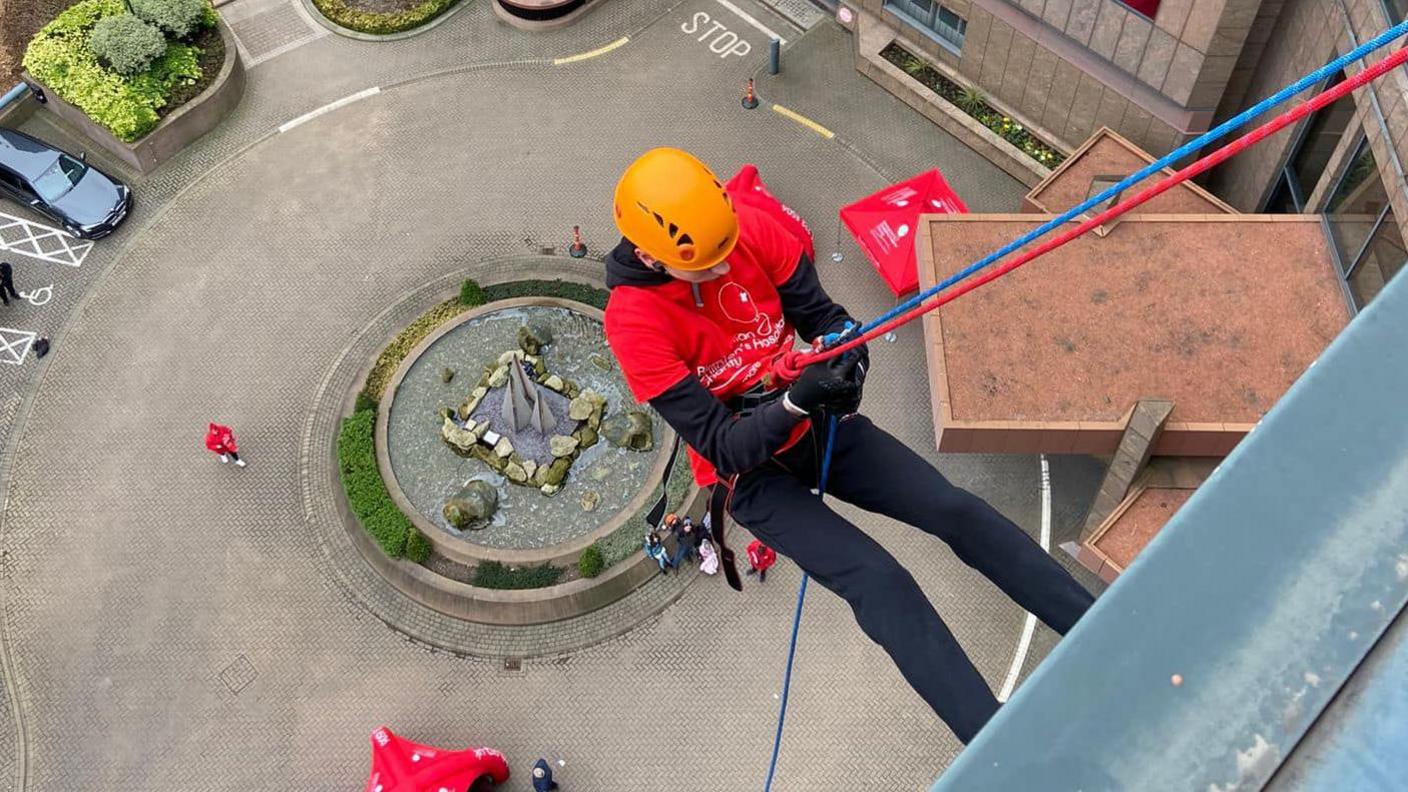 Louis Johnson abseiling down a building