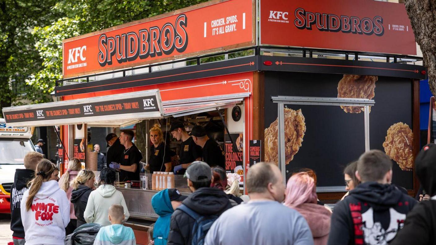 People queue up outside a pop-up catering van selling KFC
