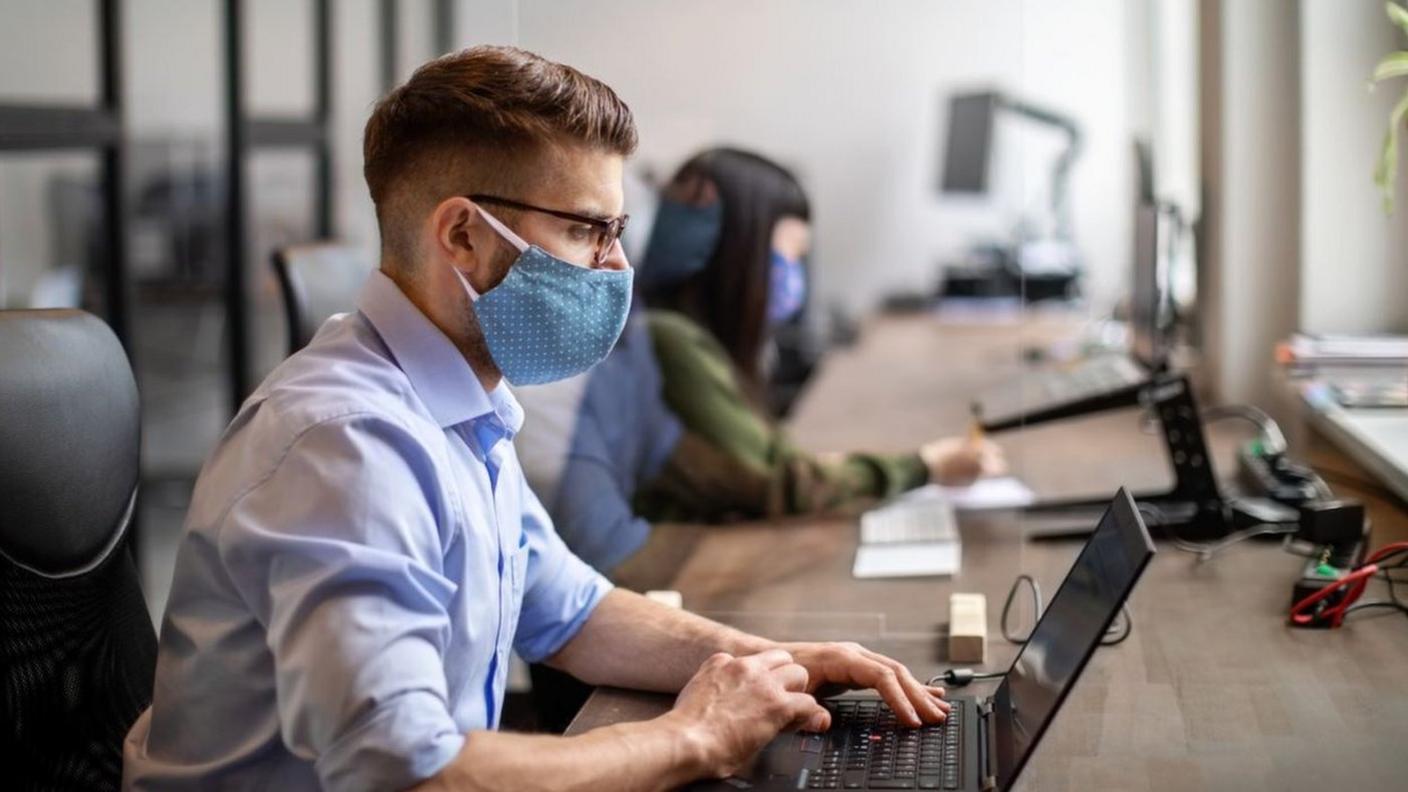 Office worker wearing a mask while sitting at desk