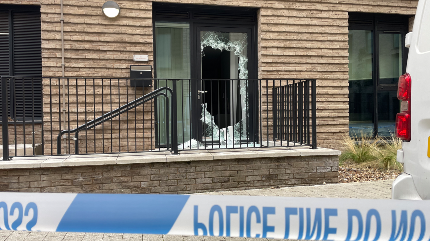 A Leicestershire Police cordon in place outside a property with a smashed front door in Alexander Street, in Leicester city centre.