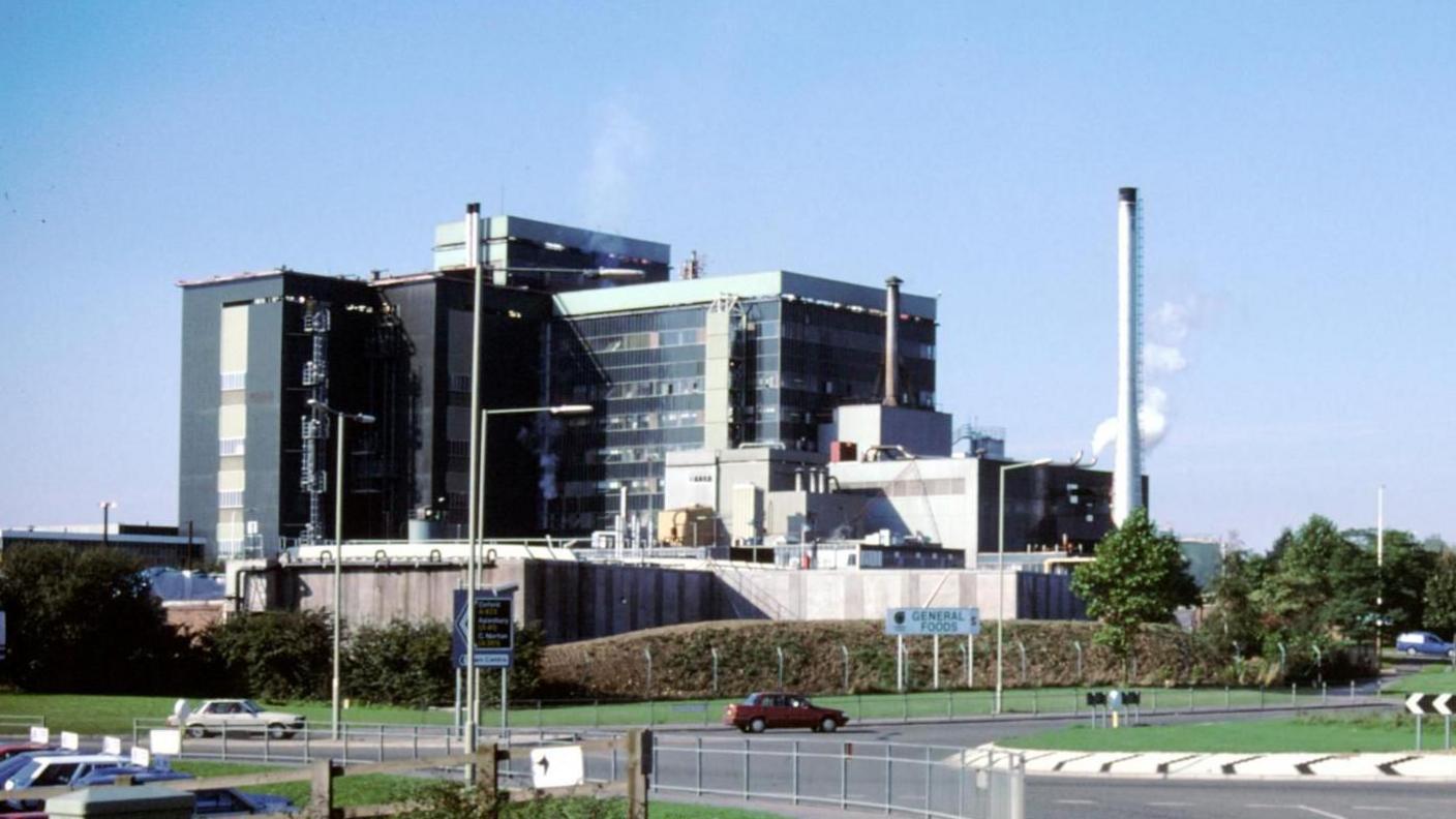 An image from 1988 of the green plant rising above a near roundabout.