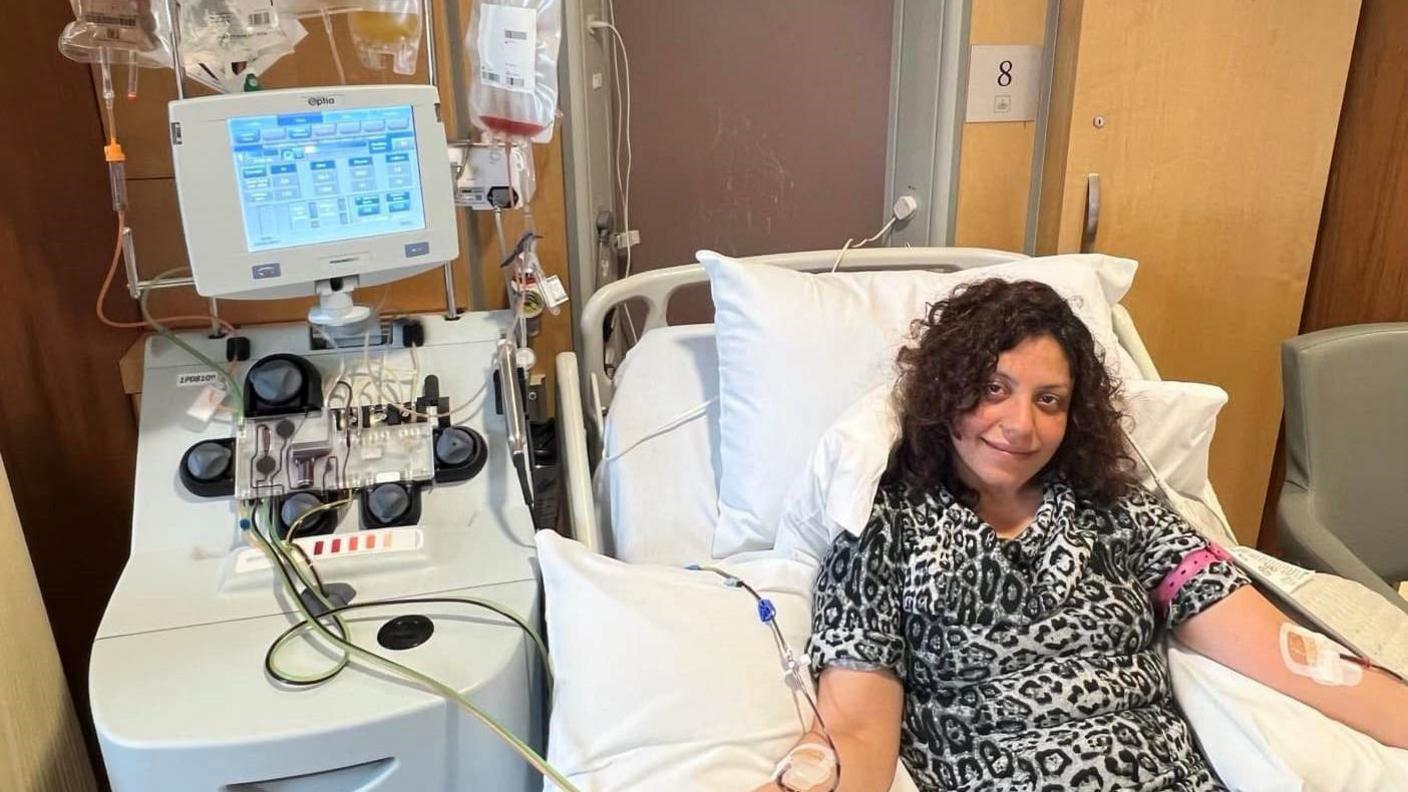 Kanan wearing a leopard print top plugged into a machine to donate stem cells in a clinic