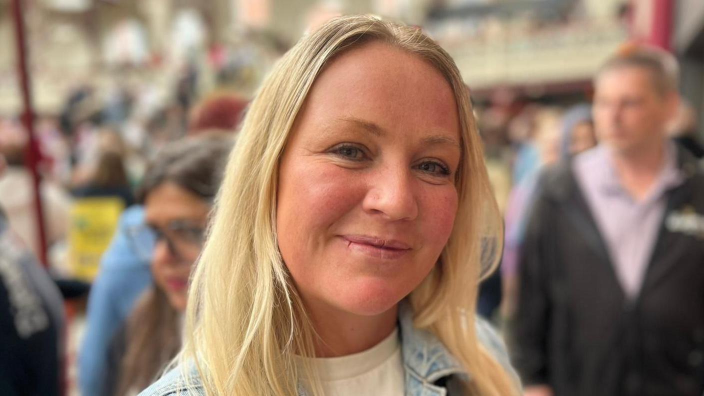 A photograph of a woman with blonde hair at the opening of the market