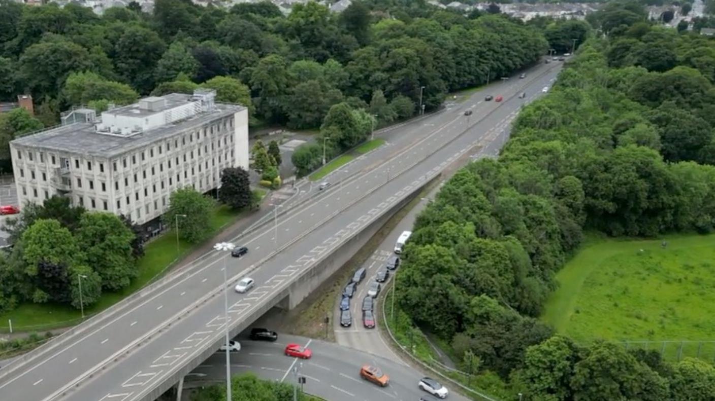 An aerial shot of Outland Road leading up to Manadon roundabout and the trees and ancient woodland that sits alongside the road
