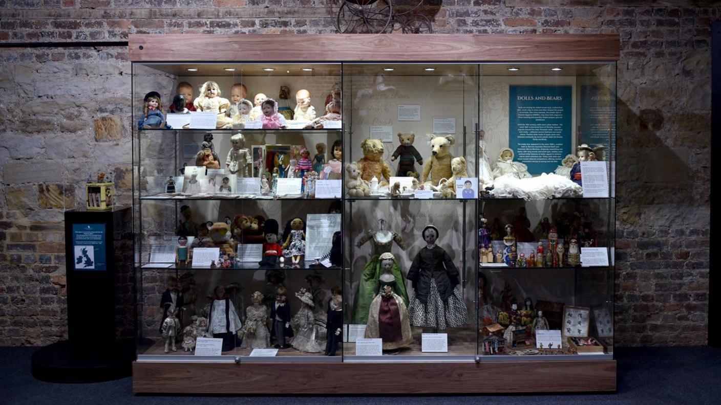 A display cabinet with a variety of dolls and teddy bears at a toy museum in Kent. 