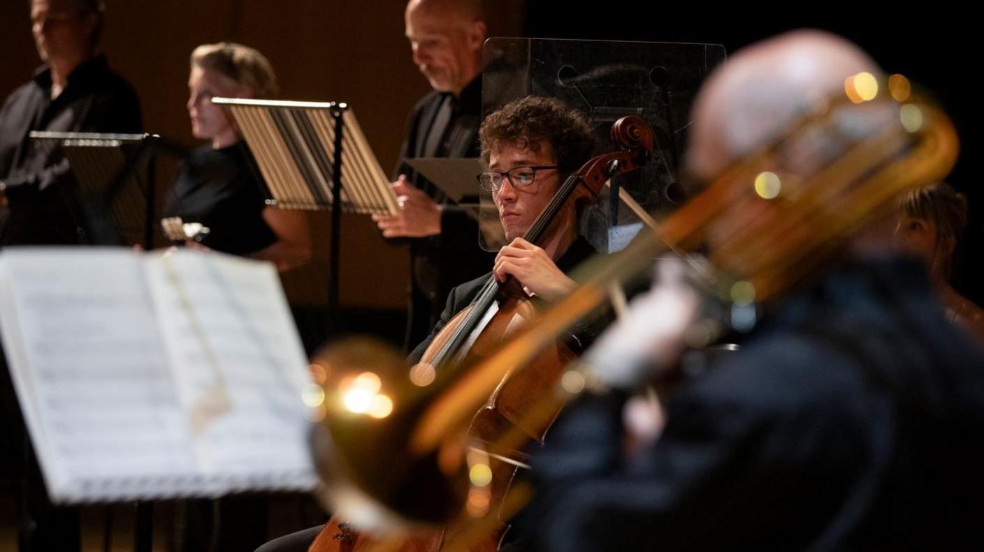 A classical music band holding trumpets and other instruments.