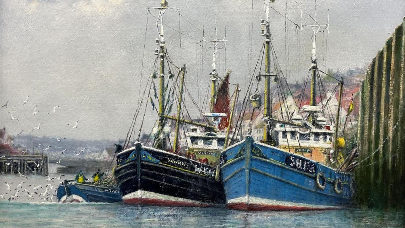 A painting by Jack Rigg of two small fishing boats, one painted blue and one black, moored side-by-side in Whitby harbour, with the town in the background and a light grey sky.