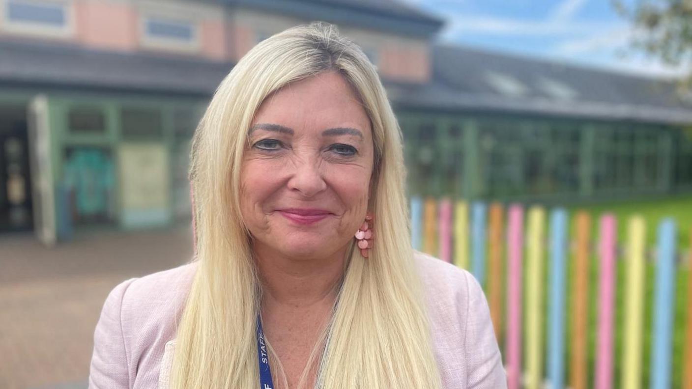 Louise Jones, head of Maes y Morfa Community School in Llanelli smiling into the camera on the schoolyard