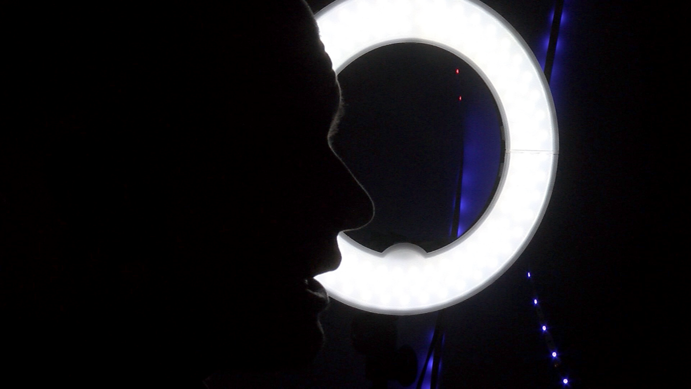 Jack is in a dark room and his silhouette is shown beside a ring light 