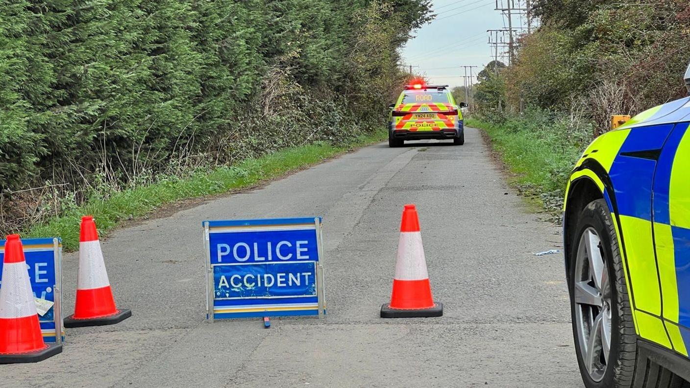 Some cones, a sign reading "police accident" sat in the road, and a police car about 40ft away flocking the road.