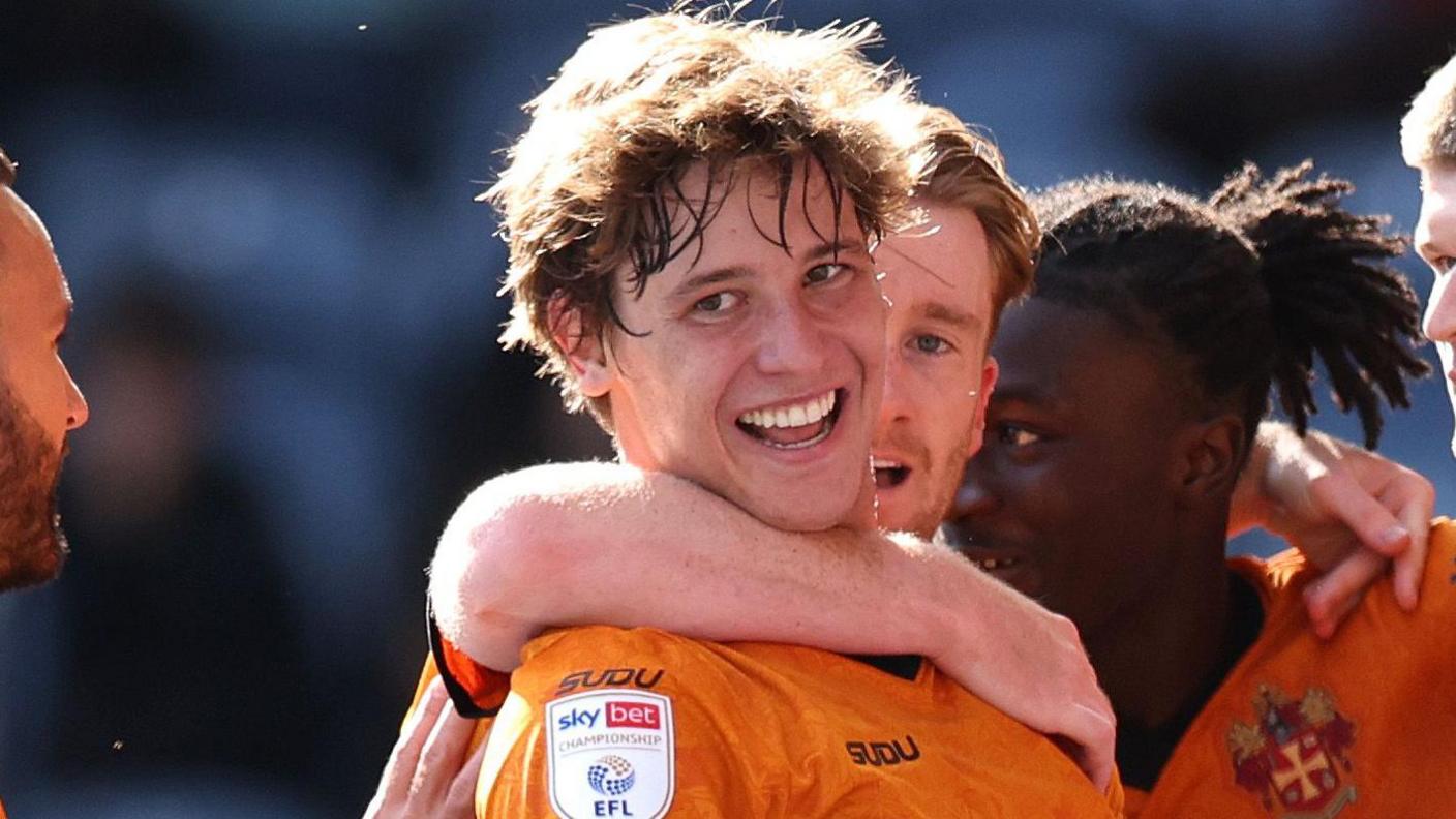 Fer López, con la camiseta local del Wolves de color oro antiguo, sonríe mientras celebra un gol contra el Preston.