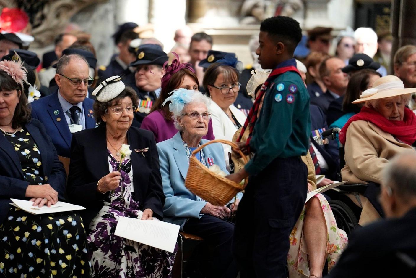 Scout giving out flowers during VE Day service.