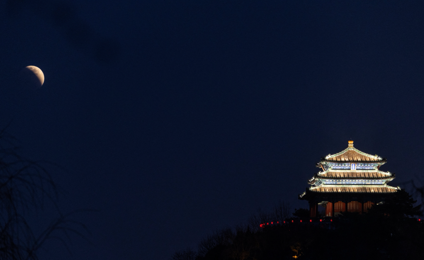 The 'Blood Moon' rises over the Wanchun Pavilion, also known as the Pavilion of Ten Thousand Springs, atop Jingshan hill during a total lunar eclipse in Beijing, China,