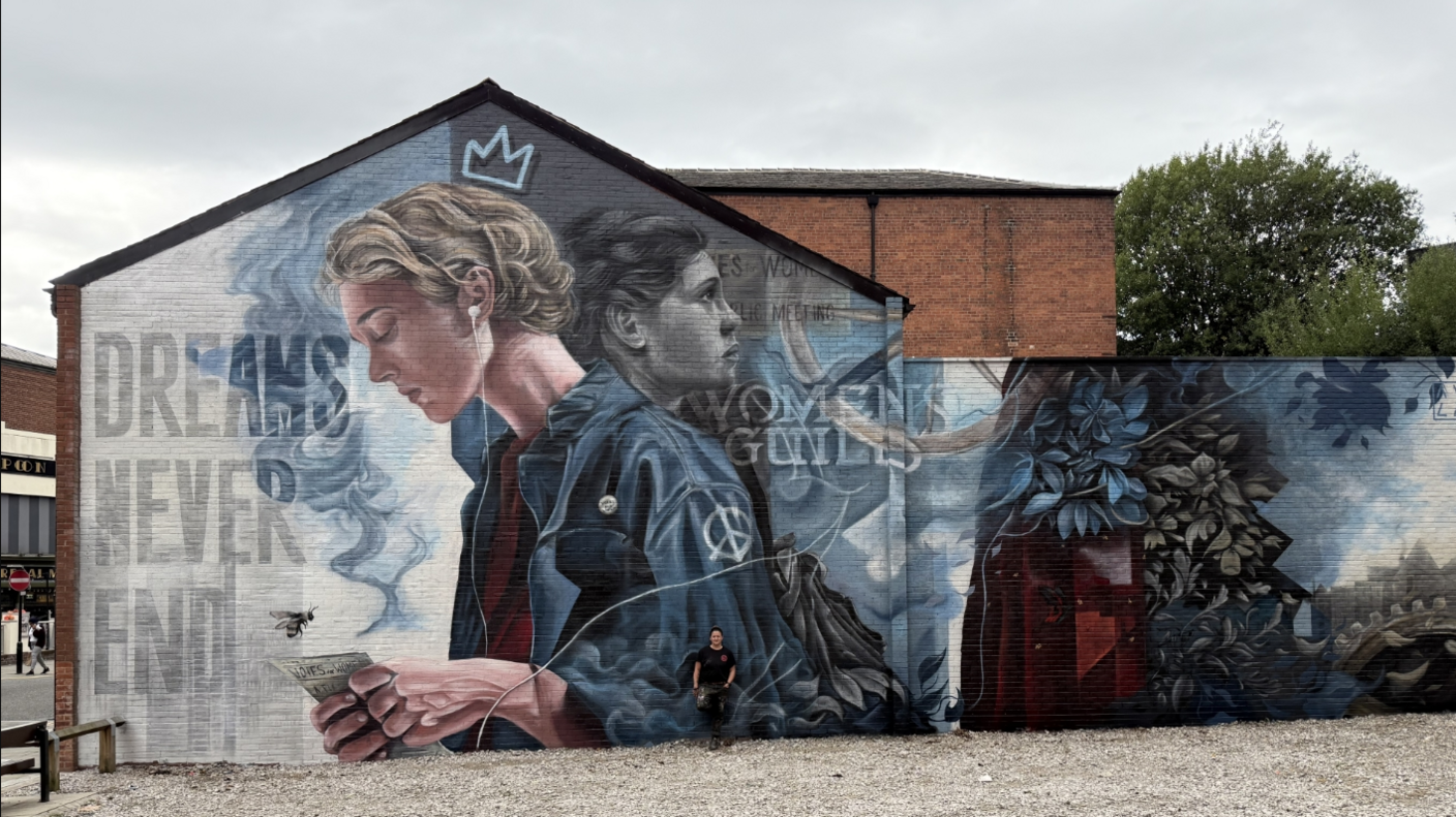A mural on a wall of a young blonde man in a black leather jacket