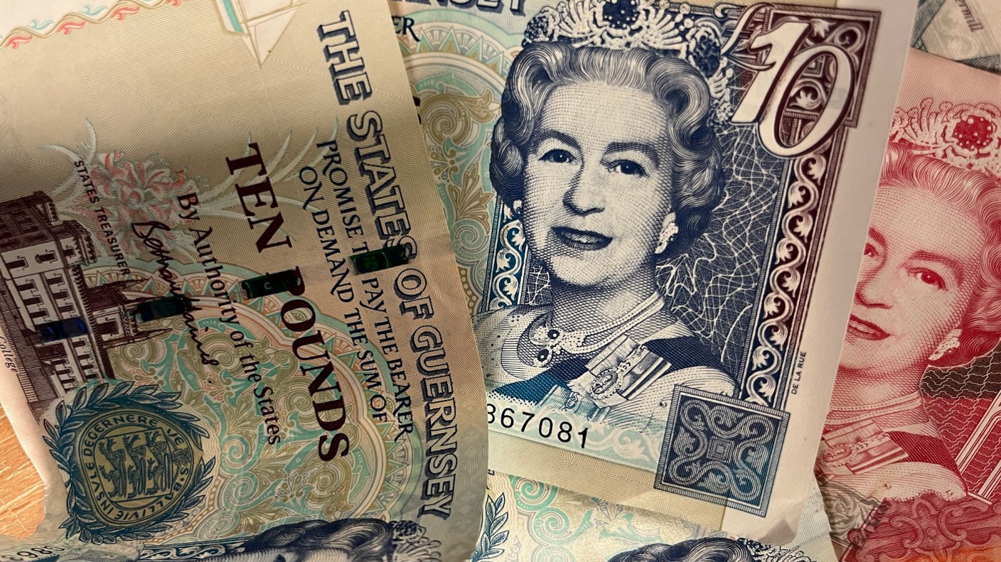 Three different notes of Guernsey currency. The feature a portrait of Queen Elizabeth II and the words THE STES OF GUERNSEY along with their denomination TEN POUNDS £10.
