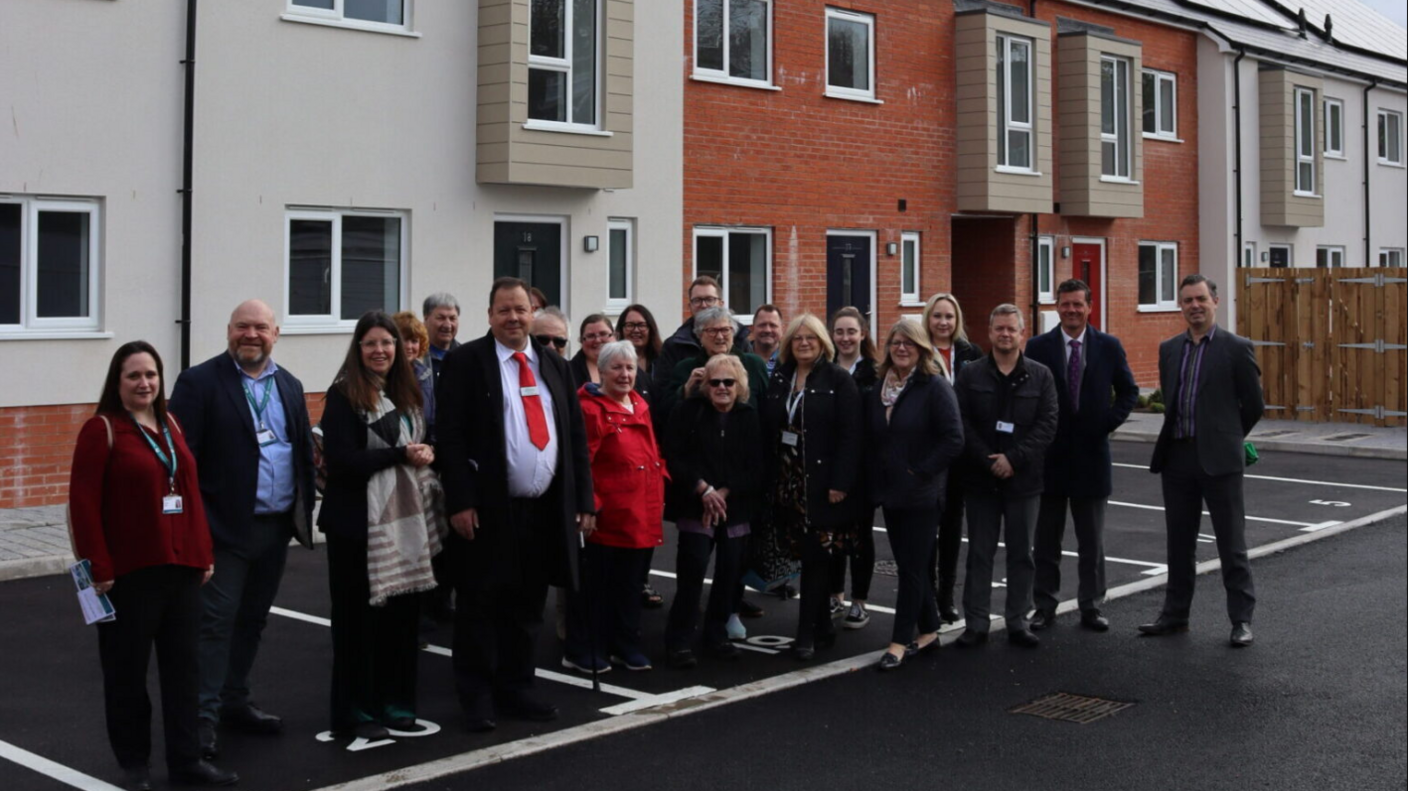 Bill Revans standing with a group of people outside new homes