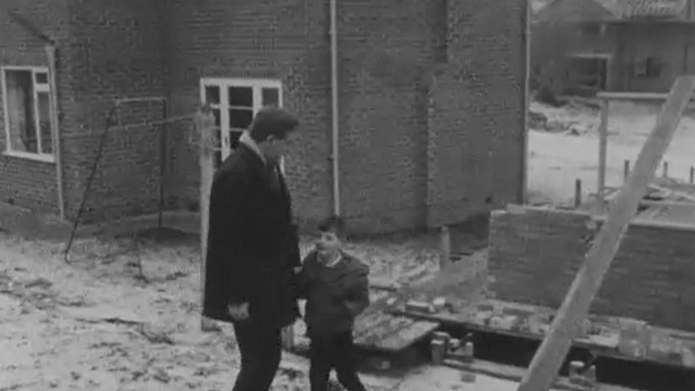 Një pamje nga seriali televiziv Chronicle, ku David Welham qëndron në një kantier ndërtimi me dëborë me prezantuesin Magnus Magnusson, duke treguar vendin ku u gjetën monedhat.