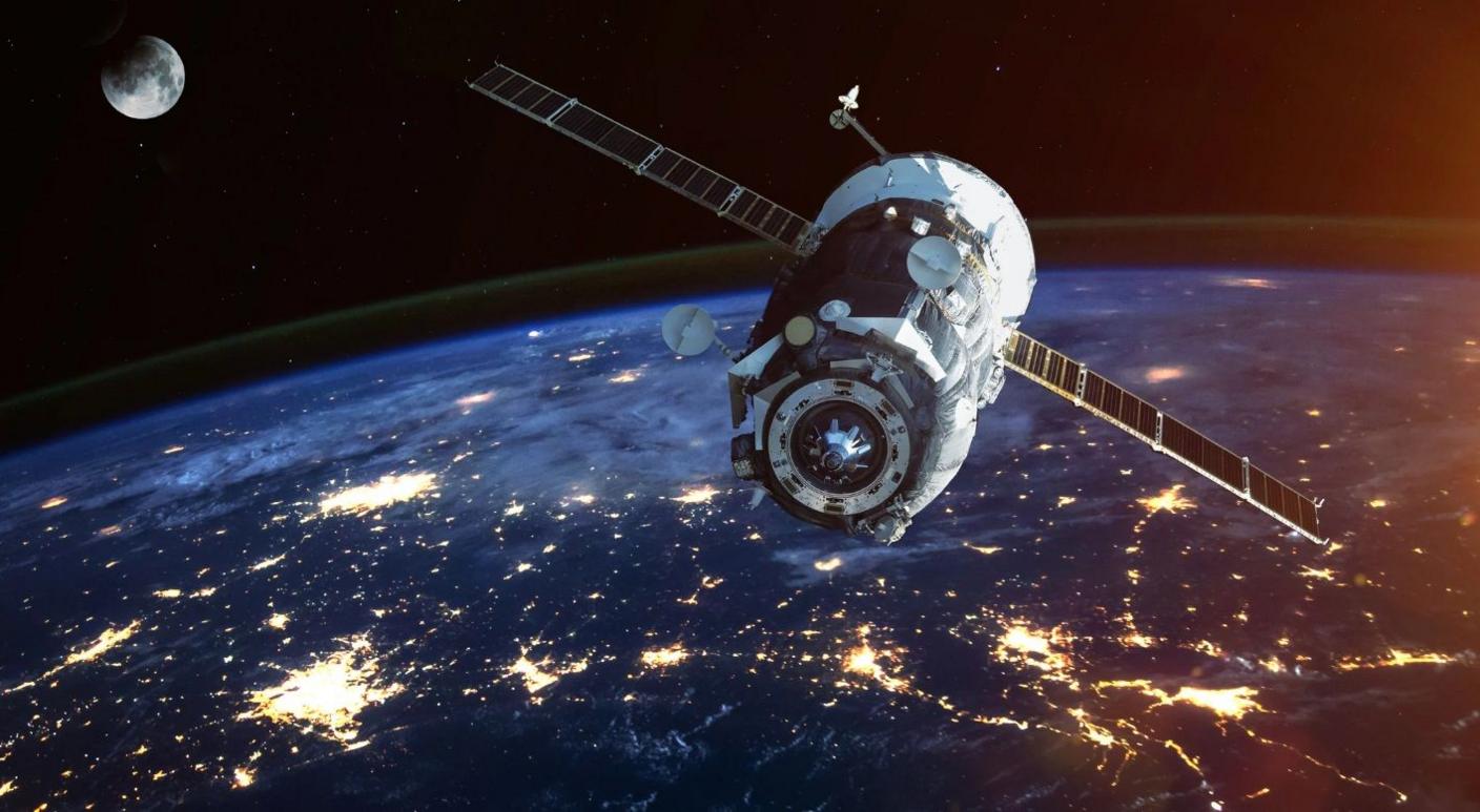 A satellite up in space. The earth can be seen in the image, as can the moon.