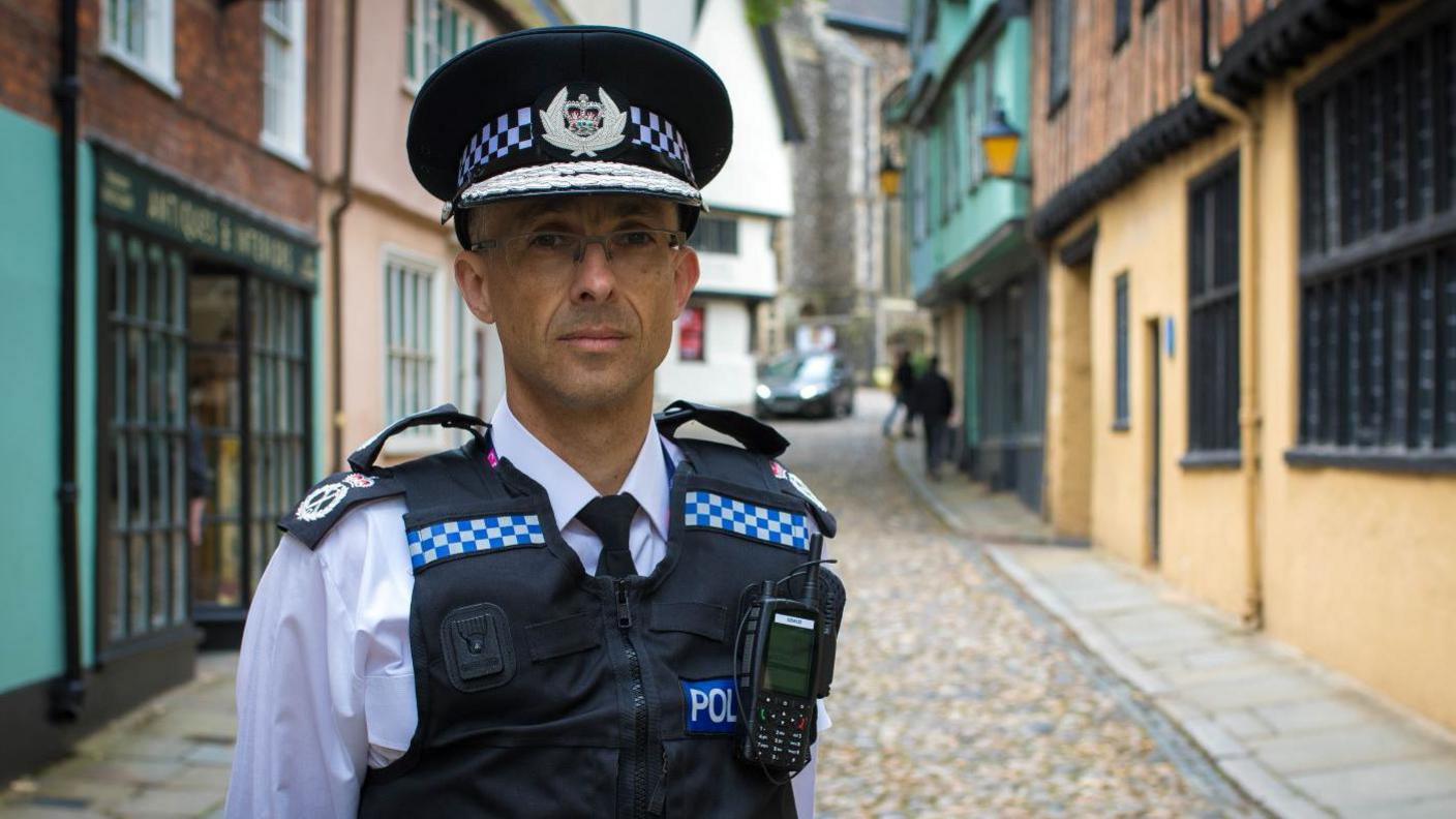 A portrait photo of Chief Constable Paul Sanford standing in a street and wearing his uniform