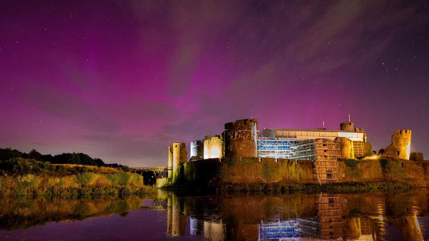 Picture of Caerphilly castle with purple hues in the background