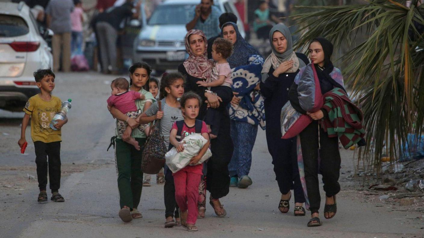 Internally displaced Palestinians, including children, walk with their belongings in central Gaza Strip. Photo: 4 June 2024