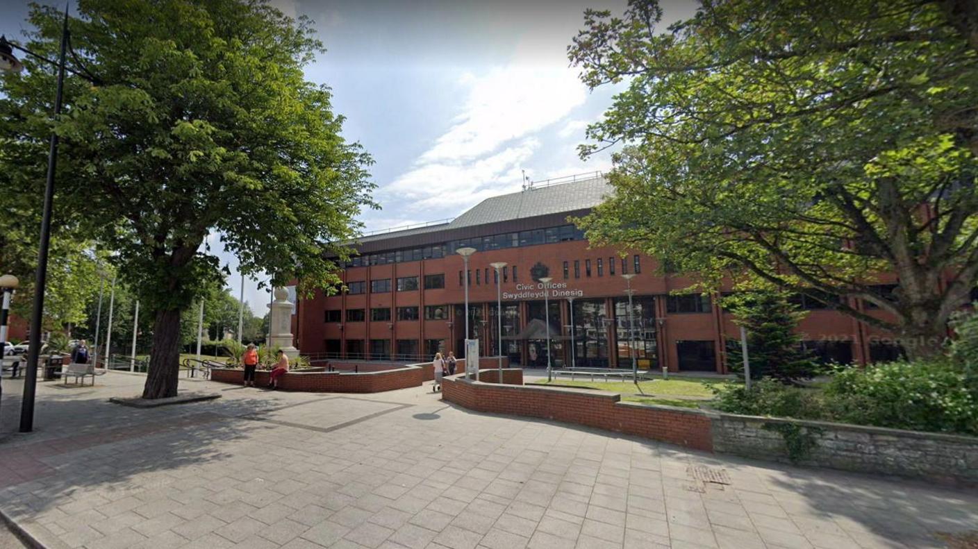 Vale of Glamorgan Council Civic Offices on Holton Road in Barry. There are trees planted either side in front of the entrance to the building.