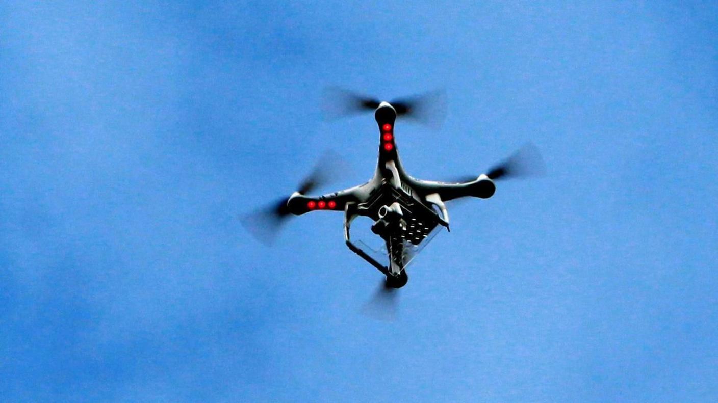 Drone flying against a blue sky