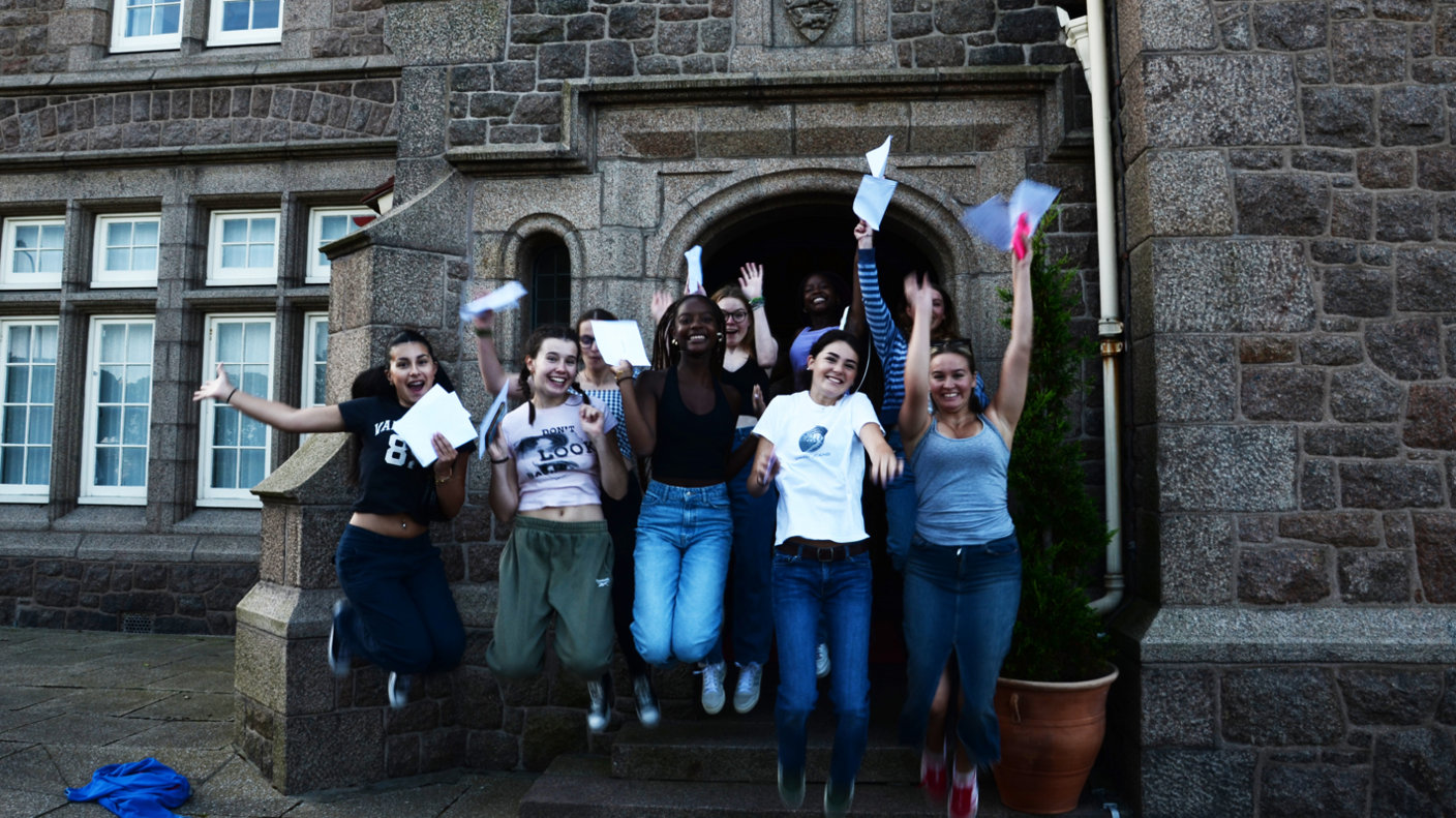 Girls jumping outside JCG celebrating exam results