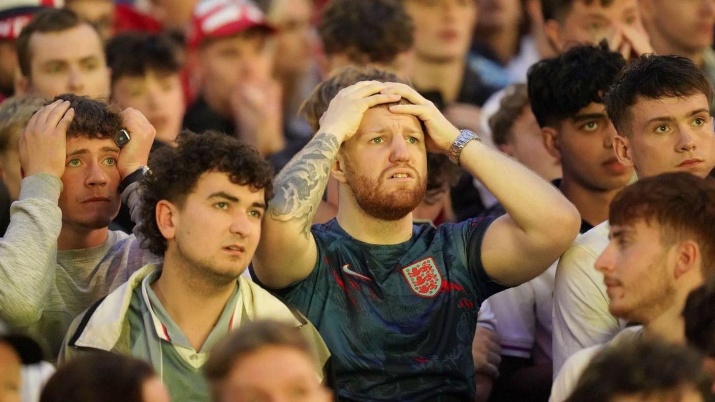 Dejected England fans watch with heads in hands