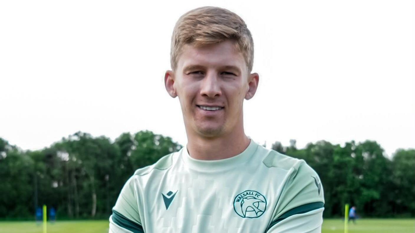 James Connolly poses for a picture in his Walsall training top at the club's training ground.