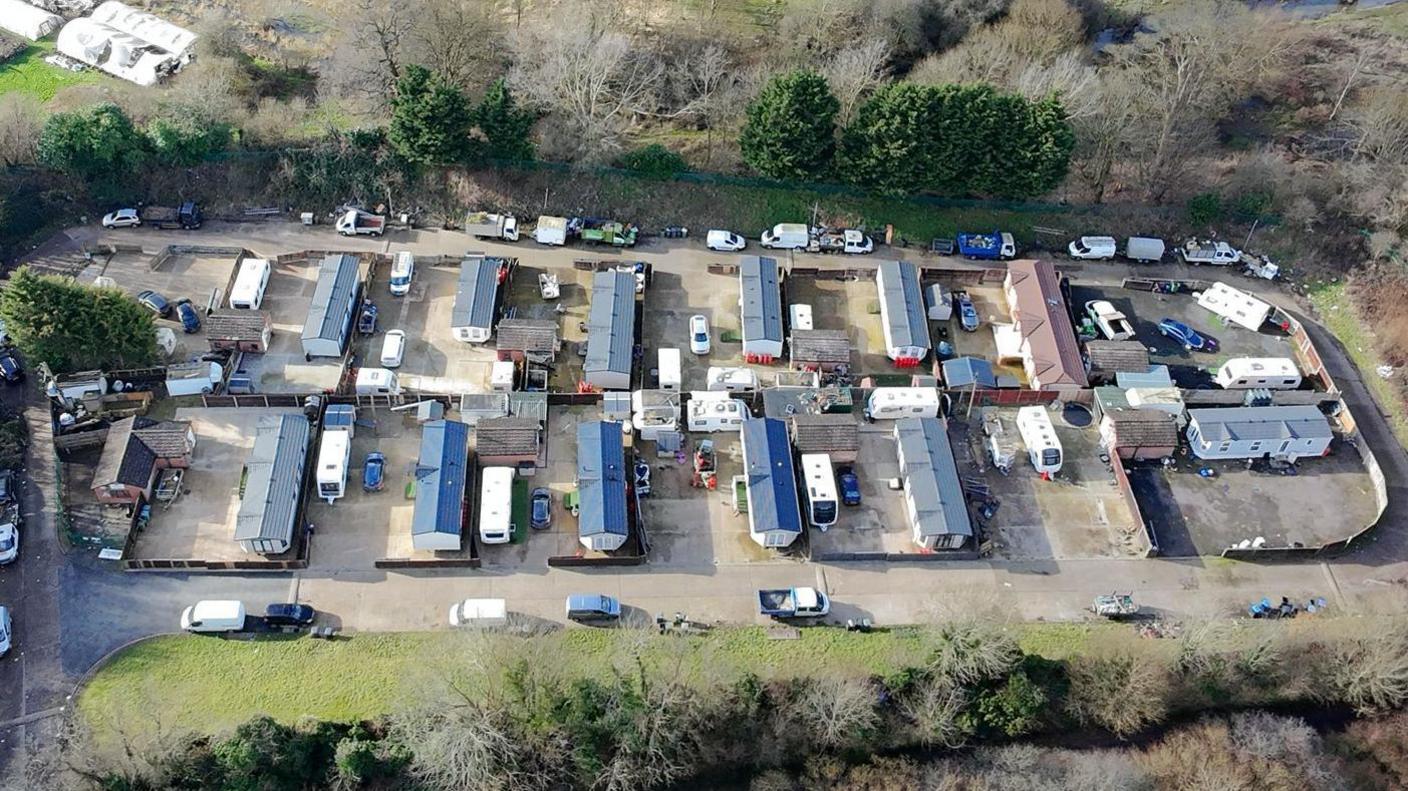 An aerial view of the Ver Meadows park, showing additional mobile caravans parked next to static caravans. The plot is surrounded by trees.
