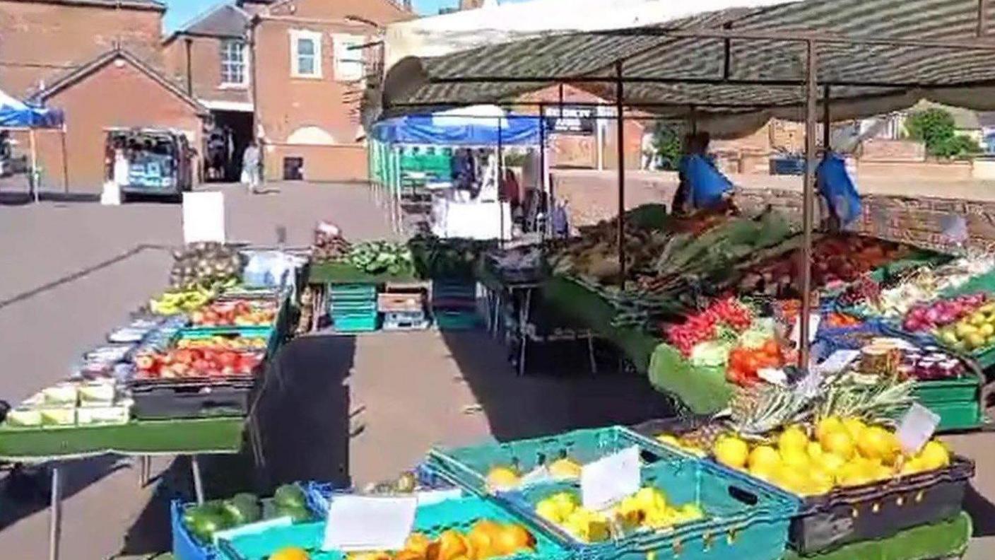 market stalls selling a variety of fruit and vegetables