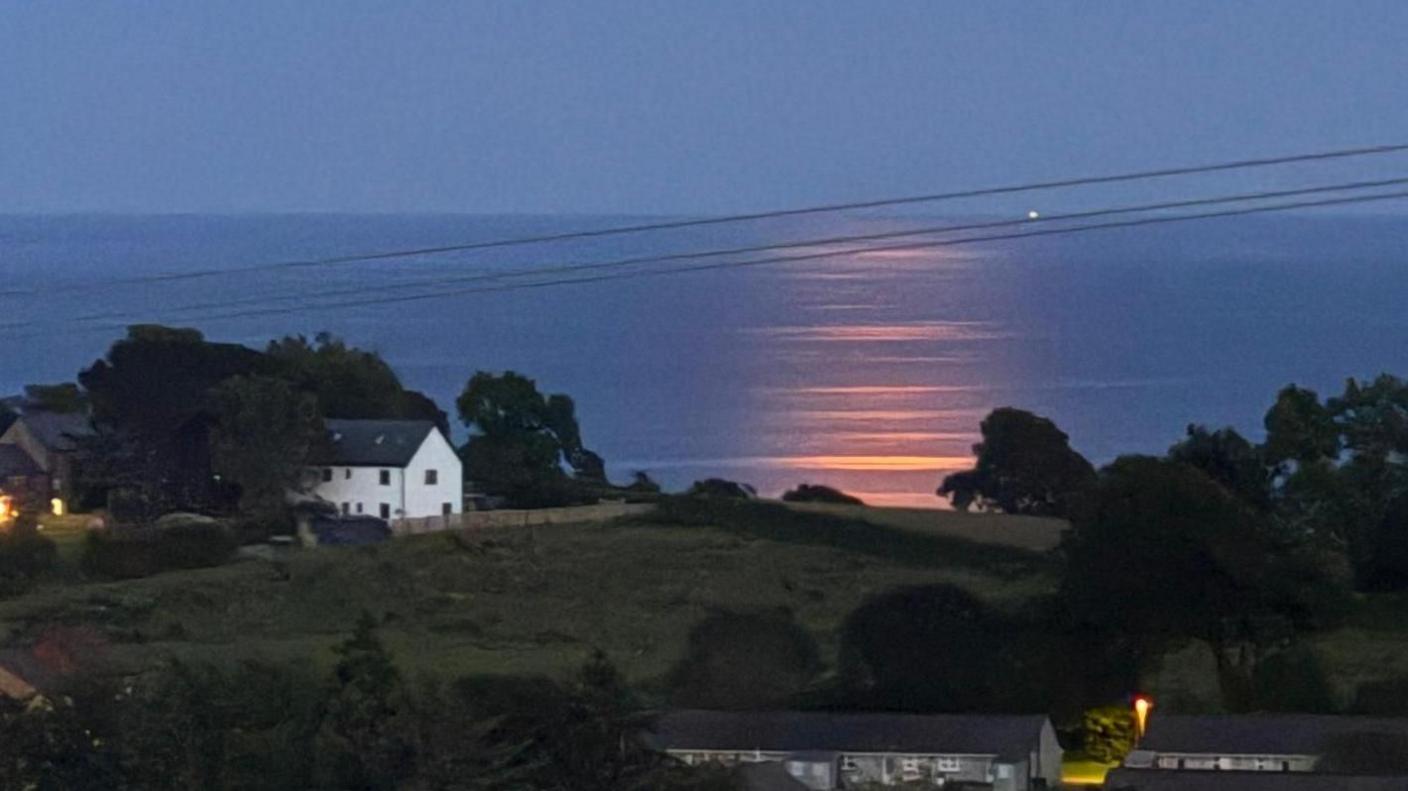 The reflection of the strawberry moon on the water in Cornwall