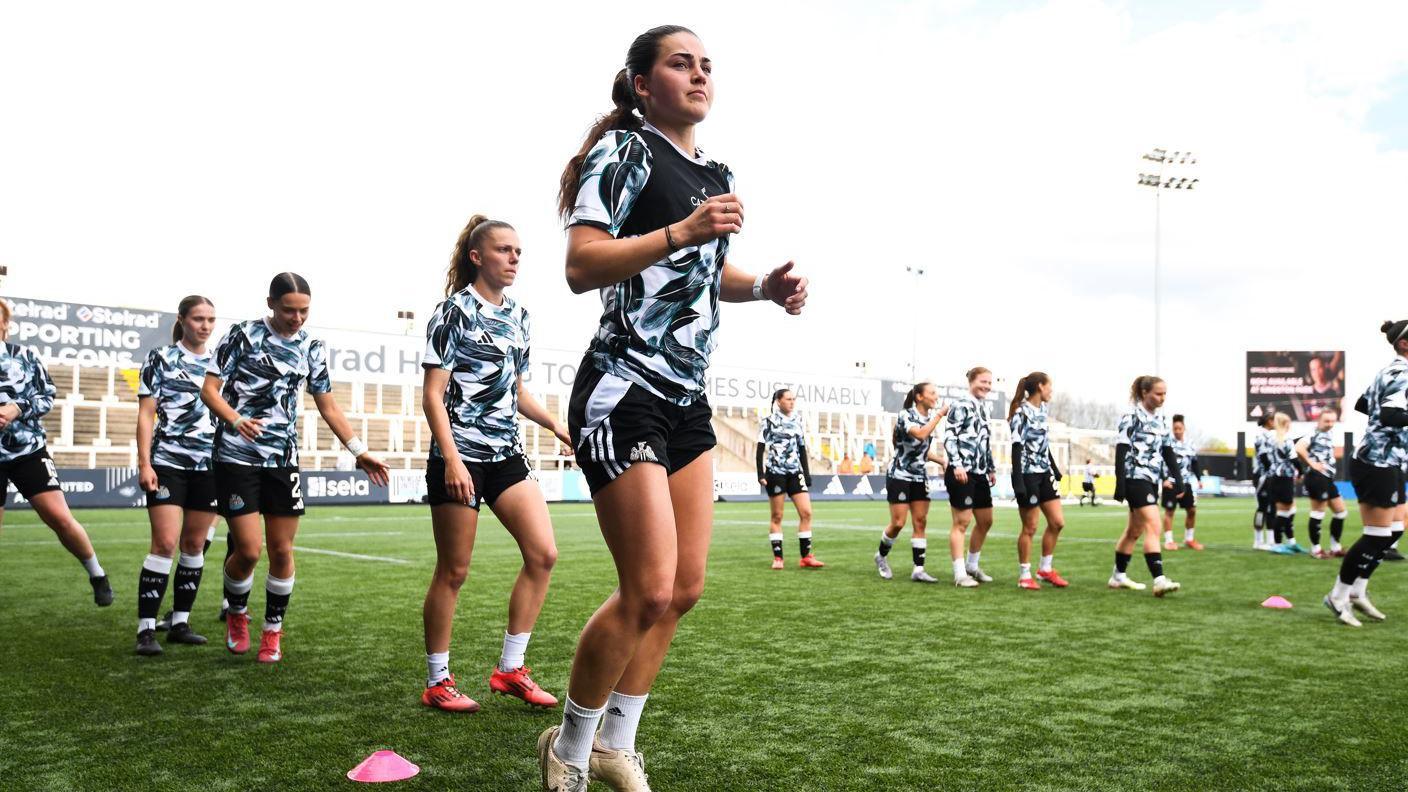 Elysia Boddy of Newcastle United warms up prior to the Barclays Women's Championship match between Newcastle United Women and Blackburn Rovers Women at Kingston Park Stadium on 13 April 2025. Other players are lined up around her.