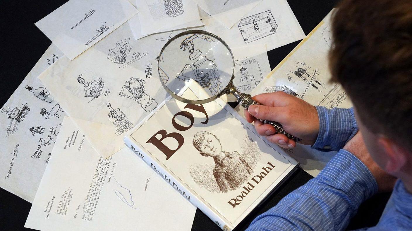 Man looking at images using a magnifying glass.