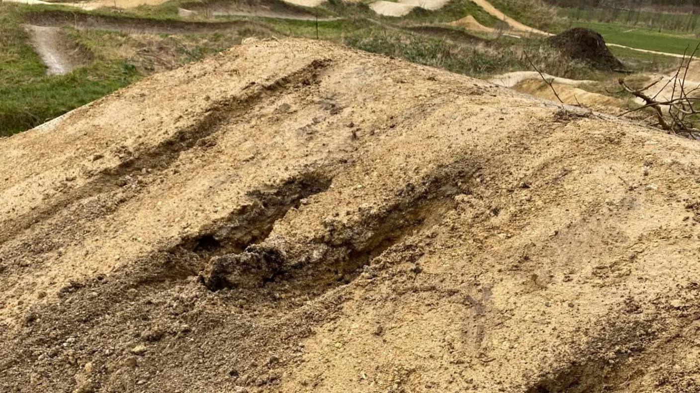 Three big holes in the ground of a BMX track.